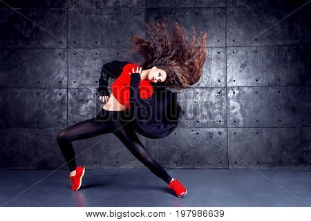 Girl dancing in front of the urban wall.
