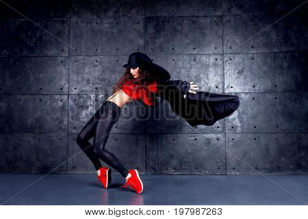 Girl dancing in front of the urban wall.