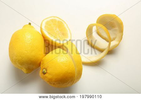 Composition with ripe lemons and twist on white background