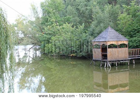 Wooden arbor on the lake in the city park