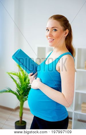 Pregnant woman doing pre-natal exercises at home