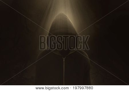 Halloween Concept, A dark and sinister figure in a hood against black.