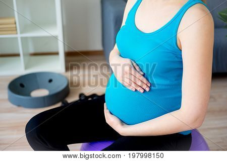 Pregnant woman doing pre-natal exercises at home