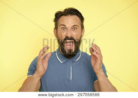 Overwhelmed With Emotions. Handsome Shouting Mature Man Screaming Standing Against Yellow Background