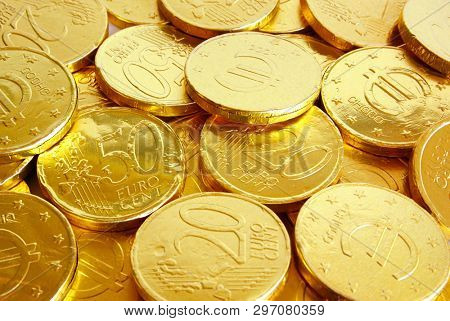 Pile of chocolate coins wrapped in shiny golden tinfoil