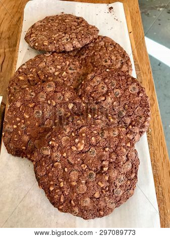 Chocolate Chip Cookies For Sale On Paper With Wooden Surface.
