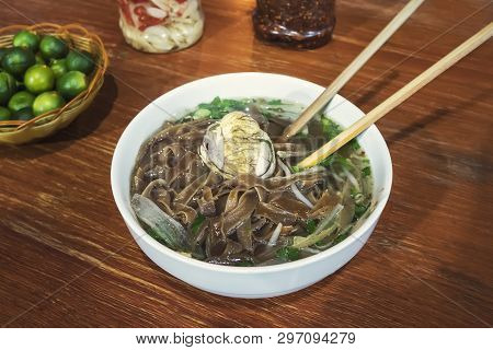 Fermented Balut Egg In A Bowl. An Exotic Soup With Pho Noodles On The Table In The Restaurant. Stree