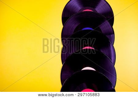 Five Vinyl Discks Placed  In A Vertical Line On Yellow Background.