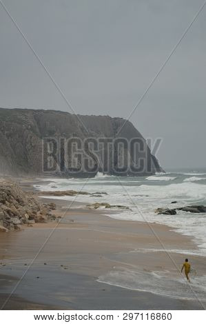 Person Leaving Evil After Surfing On A Cloudy Day At Playa Grande In Colares. Nature, Architecture, 