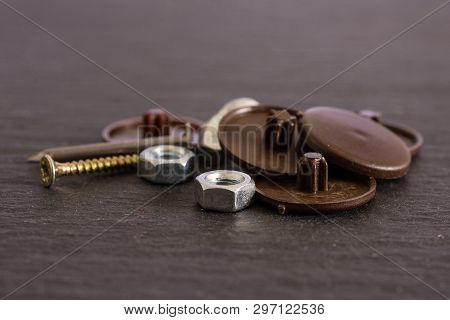 Lot Of Whole Plast Plugs, Metal Nails And Nuts Work Item On Grey Stone