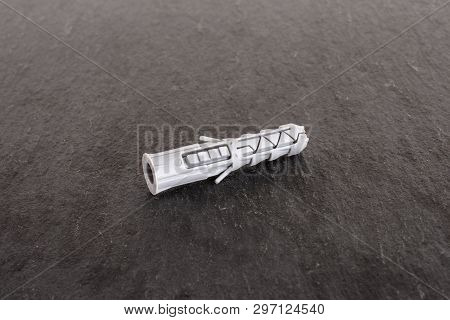 One Whole Plastic Light Grey Wall Plug Work Item On Grey Stone