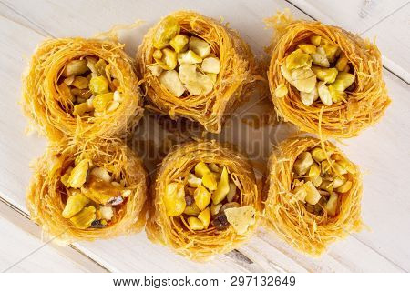 Group Of Six Whole Sweet Lebanese Baklava Piece Bird Nest Variety Flatlay On White Wood