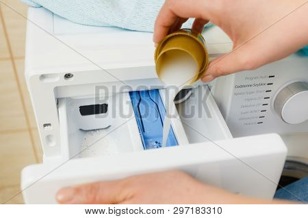 Liquid Powder Detergent And Measuring Cup Pouring Into Machine. Household Duties, Clothes Laundry Ob