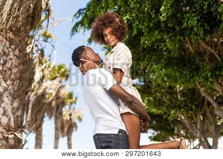 Outdoor Protrait Of Black African American Couple - Guy Carrying Girfriend On His Back