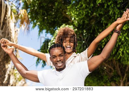 Outdoor Protrait Of Black African American Couple - Guy Carrying Girfriend On His Back