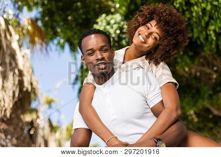 Outdoor Protrait Of Black African American Couple - Guy Carrying Girfriend On His Back
