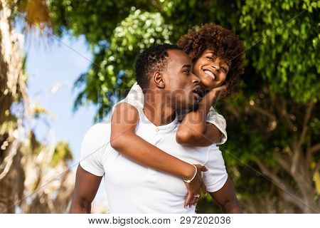 Outdoor Protrait Of Black African American Couple - Guy Carrying Girfriend On His Back