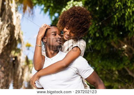 Outdoor Protrait Of Black African American Couple - Guy Carrying Girfriend On His Back