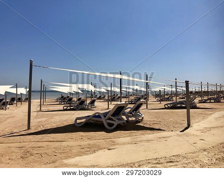 Stylish Lounger In Yellow Sand To Sun Sunbed On Beach In Summer Under Open Sky. Sunbed Intended For 