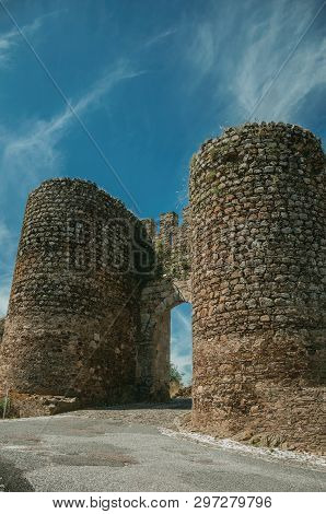 Stone Thick Towers In A Sunny Day Beside The Main Entrance Doorway On The Outer Wall Of Evoramonte. 