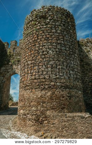 Stone Thick Towers In A Sunny Day Beside The Main Entrance Doorway On The Outer Wall Of Evoramonte. 