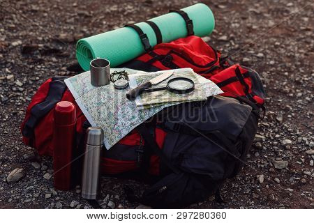 Close Up Shot Of Travel Equipment, Backpack, Map, Compass, Knife, Sleeping Pad On The Ground At Moun