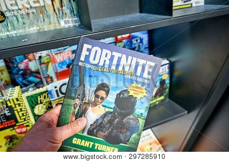 Amsterdam, Netherlands - October 08, 2018: Fortnite Hardcover Ultimate Strategy Guide In A Hand Over