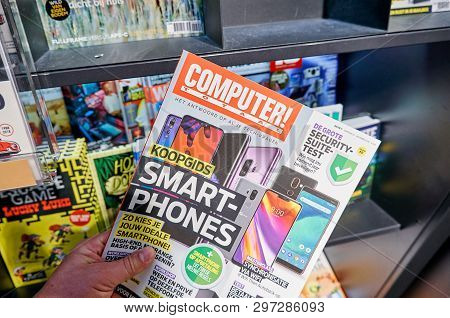 Amsterdam, Netherlands - October 08, 2018: Computer Totaal Magazine In A Hand Over A Stack Of Magazi