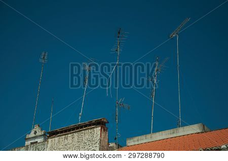 Set Of Television Antennas On Top Of Roof With Blue Sky In The Background At Campo Maior. A Cute Lit