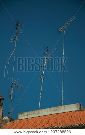 Set Of Television Antennas On Top Of Roof With Blue Sky In The Background At Campo Maior. A Cute Lit