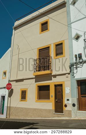 Stop Road Sign In Front Colorful House With Terrace On Sunny Day, In An Empty Street Of Campo Maior.