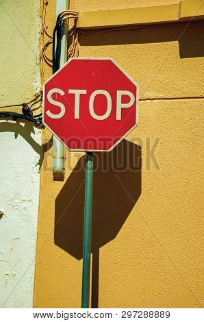 Close-up Of No Entry Road Sign In Front Of Yellow Rough Plaster Wall, In A Sunny Day At Campo Maior.