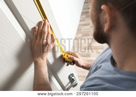 Man Measuring Door In Room, Closeup. Construction Tool