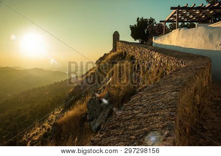 Stone Wall And Old House Over Rocky Cliff, With Hilly Landscape And Sunset Glow At Marvao. An Amazin