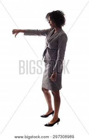 Side View Of A Black Businesswoman Gesturing Disapproval By Doing A Thumbs Down.  She Is Isolated On