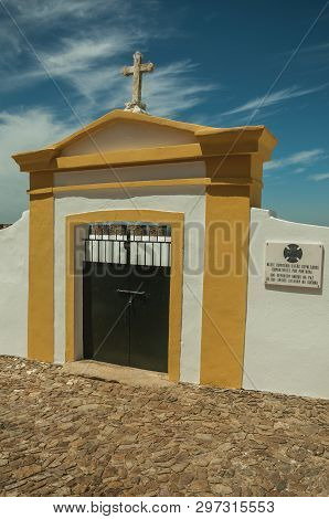 Evoramonte, Portugal - July 6, 2018. Colorful gateway in graveyard wall in the main street of Evoramonte. A tiny fortified civil parish over hill where stands out its historic castle in Portugal.