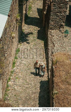 Castelo De Vide, Portugal - July 10, 2018. Old Couple Walking On Cobblestone Path Inside The Castelo
