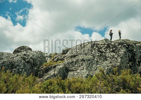 Serra Da Estrela, Portugal - July 12, 2018. Couple Of Hikers On Top Of Rocks At Highlands In The Ser