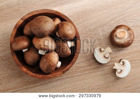 Fresh Brown Chestnut Mushrooms Whole In Wooden Plate And Slised Mushrooms On Wooden Background - Top
