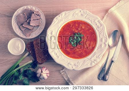 Soup In A Bowl With Dill, Sour Cream, Beef And Black Bread On Wooden Background - Top View - Borsh -