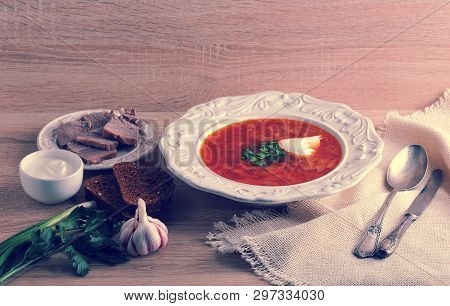 Soup In A Bowl With Dill, Sour Cream, Beef And Black Bread On Wooden Background - Borsh - National D