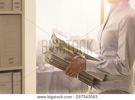 Office Worker Carrying Paperwork In The Office