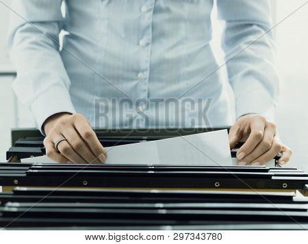 Office Worker Searching Files In The Archive