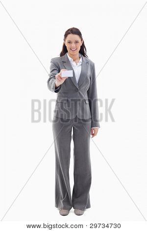Smiling businesswoman smiling showing a card against white background