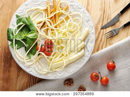 Cheese On A Plate With Tomatoes And Basil - Suluguni, Chechil, Smoked Cheese On Wooden Background - 