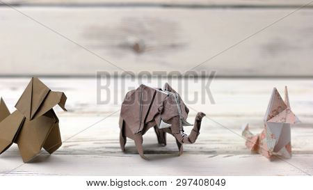 Set Of Origami Animals On Wooden Background. Collection Of Paper Animal Models On White Wooden Table