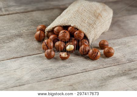 Macadamia Nut On A Wooden Table In A Bag, Closeup, Top View