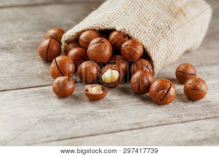 Macadamia Nut On A Wooden Table In A Bag, Closeup, Top View