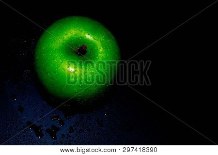 Green Ripe Apple With Water Droplets On A Dark Background, Closeup