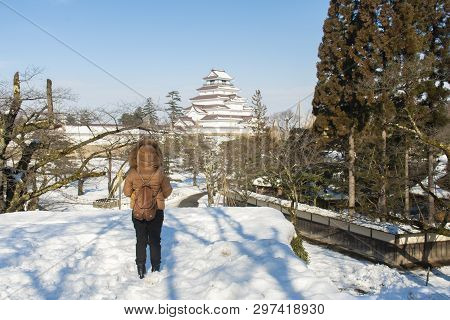 Asian Woman Is Enjoy Traveling At Tsuruga-jo Castle In Fukushima, Japan During Winter.